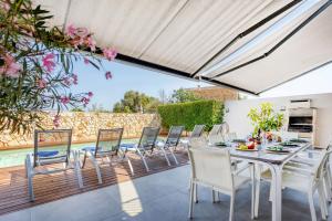 een terras met een tafel en stoelen en een zwembad bij Casa Reiet by dracmallorca in Santanyi