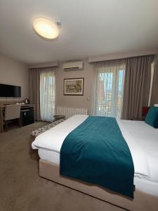 a large bedroom with a large bed and a desk at Hotel VIP in Sarajevo