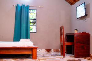 una camera da letto con un letto e una tenda blu di Le Jardin Arhumatic Sambava a Sambava