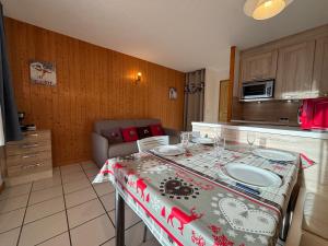 une cuisine avec une table recouverte d'une nappe dans l'établissement Résidence Atrey 103 Clés Blanches Courchevel, à Courchevel