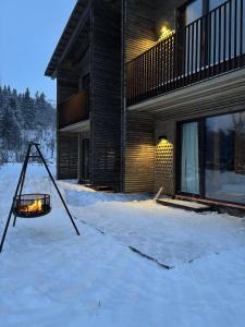 una casa en la nieve frente a un edificio en Architect Designed Mountain Cabin At Kvitfjell, en Favang