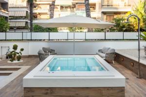 a pool on the roof of a building with an umbrella at Pool & Spa Deluxe in Rome