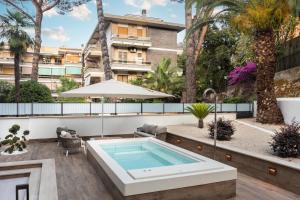 an outdoor pool with a hot tub and a building at Pool & Spa Deluxe in Rome