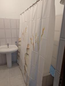 Cozy 3 Bdr at Praia Da Laginha في منديلو: حمام مع ستارة دش مع حوض