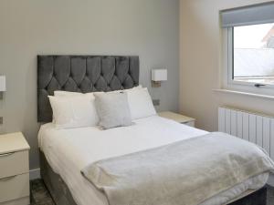 a bedroom with a large bed with a large headboard at Little Fawn in Otterburn