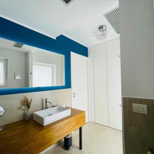 ein Badezimmer mit einem weißen Waschbecken und einer blauen Wand in der Unterkunft Wellness Hillside House In Le Marche in Recanati + 15 Fotos