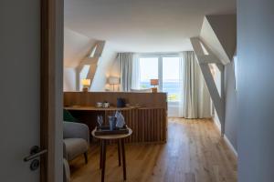 a room with a desk and a bed with a window at Logis Hôtel de Carantec in Carantec