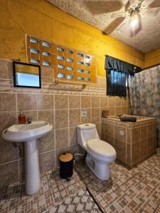 een badkamer met toilet en wastafel bij 4 Amigos El Zonte in ChiltiupÃ¡n