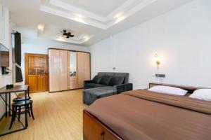 a bedroom with a bed and a chair and a couch at Taladnoi Paint House in Bangkok