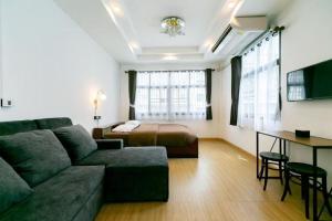 un soggiorno con un divano e un letto di Taladnoi Paint House a Bangkok
