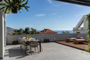 een terras met een tafel en stoelen op een balkon bij Casa Tabaibo by An Island Apart in Funchal
