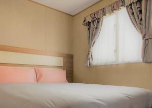 a bedroom with a bed and a window at The Chase Holiday Park in Winthorpe +5 photos