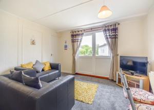a living room with a couch and a television at Ravenna Holiday Park in Anderby