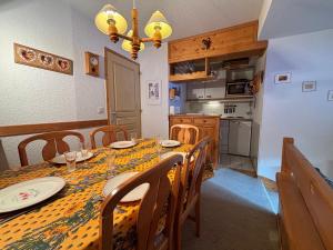 ein Esszimmer mit Tisch und eine Küche in der Unterkunft Résidence Atrey 205 Clés Blanches Courchevel in Courchevel + 12 Fotos