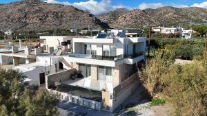 eine Luftaufnahme eines Hauses mit Bergen im Hintergrund in der Unterkunft Luxury Villa Asana in Koutsourás