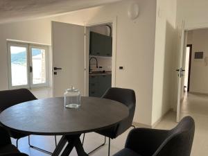 La Casa nel Borgo في نوسيرا أومبرا: طاولة وكراسي في غرفة مع مطبخ +3 صور