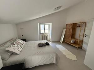 Un dormitorio blanco con una cama grande y una ventana. en La Casa nel Borgo, en Nocera Umbra