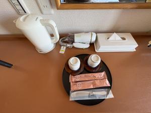 彦根市にある彦根びわこホテル無料駐車場ありペット同伴可のコーヒーカップ2個とランプが置かれたテーブル +10枚の写真