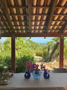 tre vasi blu con fiori appoggiati su un tavolo di CasAmare a Pizzolungo