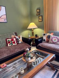 a living room with two couches and a glass table at 4 Seasons Apartment in Leskovik +17 photos