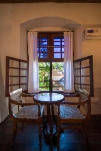 a table and chairs in a room with a window at Old Courtyard Hotel in Cochin