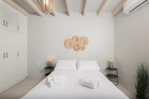 a white bedroom with a bed with towels on it at Loft Nikando in Tsilivi