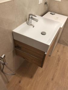 a white sink in a bathroom with a wooden floor at Casa Nelly by Ca-Sa Check in Andalo +16 photos