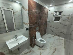 a bathroom with a toilet and a sink at Expo Residency Inn in Jāmb +8 photos