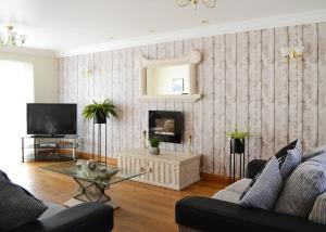 a living room with a couch and a tv at Aberdwylan Holiday Park in Abercych