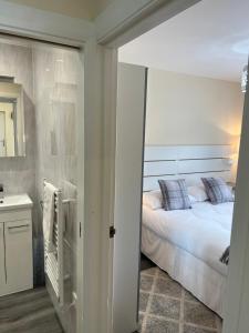 a bedroom with a bed and a sink and a mirror at Canal View Cottage in Winchburgh