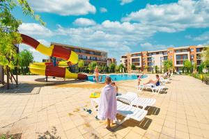 een groep mensen bij een zwembad met een glijbaan bij Holiday and Orchid Fort Noks Apartments in Sunny Beach