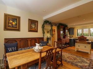eine Küche und ein Wohnzimmer mit einem Holztisch in der Unterkunft White House in Mickleton