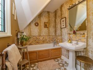 ein Badezimmer mit Badewanne, Waschbecken und Spiegel in der Unterkunft White House in Mickleton + 77 Fotos