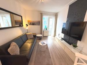 a living room with a couch and a large flat screen tv at Haus Solymar, Whg 44 in Grömitz +5 photos
