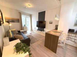 a living room with a couch and a tv at Haus Solymar, Whg 44 in Grömitz