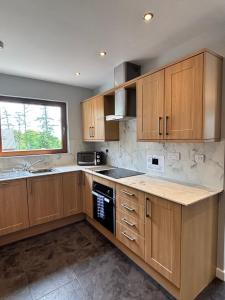 Lord Galloway 34 with Hot Tub في نيوتن ستيوارت: مطبخ فارغ مع دواليب خشبية ونافذة