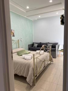 een slaapkamer met een bed en een bank bij MIRO'S Casa Vacanze Pompei in Pompei