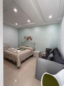 een slaapkamer met een bed en een bank erin bij MIRO'S Casa Vacanze Pompei in Pompei