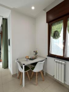 een eetkamer met een tafel en twee stoelen bij MIRO'S Casa Vacanze Pompei in Pompei +26 foto's