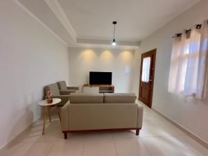 a living room with a couch and a tv at Vila dos Pinheiros 3 in Serra Negra