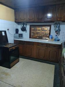 Zack's Serene House في Kisii: مطبخ مع خزائن خشبية وفرن موقد