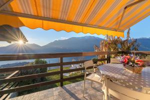 a table and chairs on a balcony with a view at Lake Como - Incanto in Valvarrone