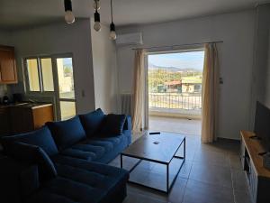 un soggiorno con un divano blu e un tavolo di Athens Airport Luxury Apartment a Spata