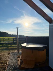 - un bain à remous sur une terrasse avec vue sur un champ dans l'établissement Leśna Balia - Domek z balią na wyłączność, à Stogniewice