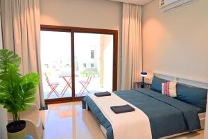 Un dormitorio con una cama y un balcón con una mesa. en Wateera Jebel Sifah-Beachfront, en As Sīfah 12 fotos más