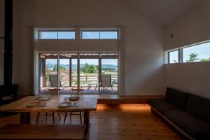 a living room with a table and a couch at 一棟貸切Azumino36Stay 安曇野の静かな隠れ家 貸切サウナ BBQ 絶景テラス in Azumino