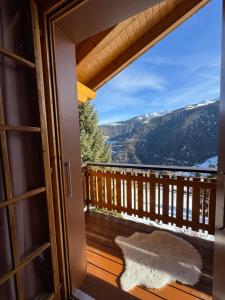 a door to a balcony with a view of the mountains at Chalet Famicha by Jolidi in Nendaz