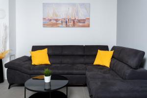 a living room with a black couch and yellow pillows at Villa Lotta by Istrialux in Labin