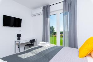 a bedroom with a bed with a desk and a window at Villa Lotta by Istrialux in Labin