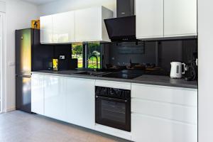 a kitchen with white cabinets and a black oven at Villa Lotta by Istrialux in Labin